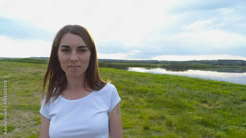 Young beautiful girl in dress goes on green field Young beautiful girl in dress goes on green field
