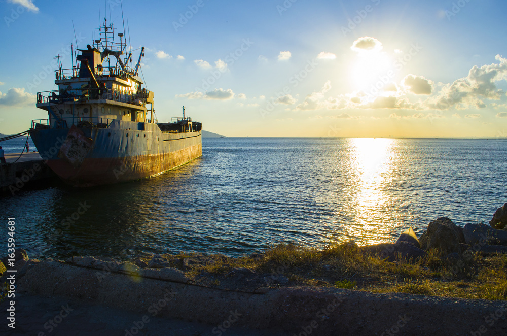 Sun shining through bow of cargo ship