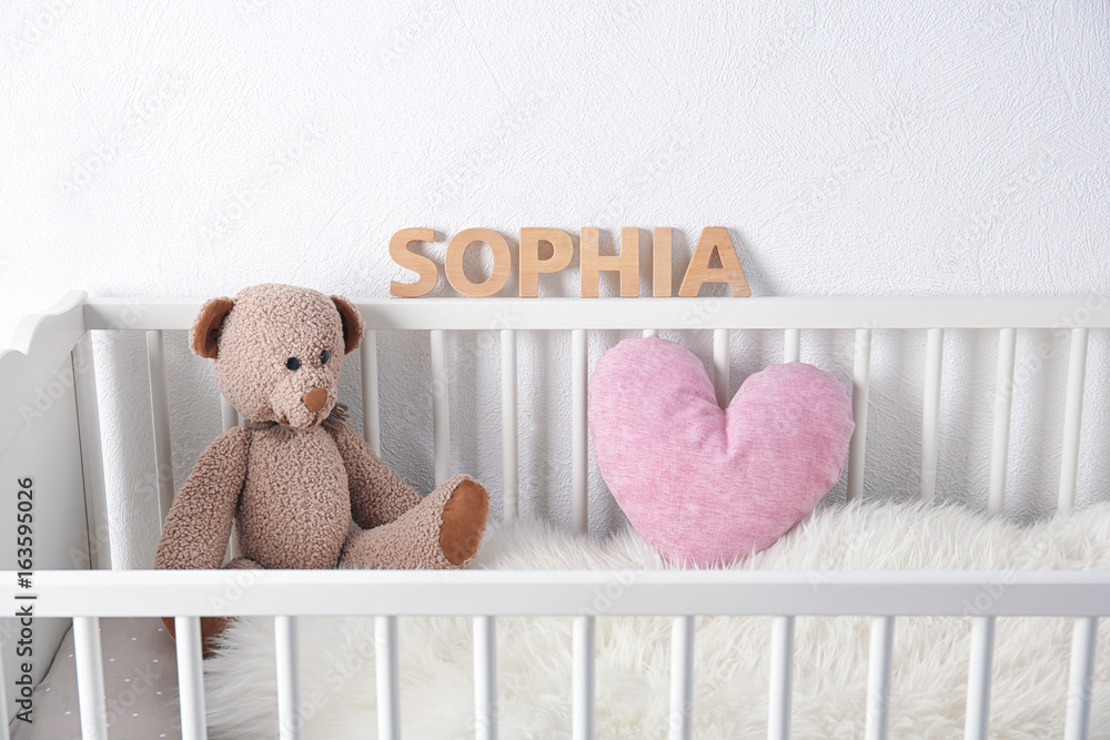 Baby name SOPHIA composed of wooden letters on crib rail. Choosing name concept Stock Photo