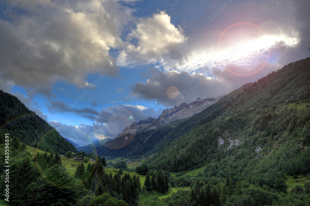 Sun peeking from behind the clouds over Val Bedretto, Switzerland