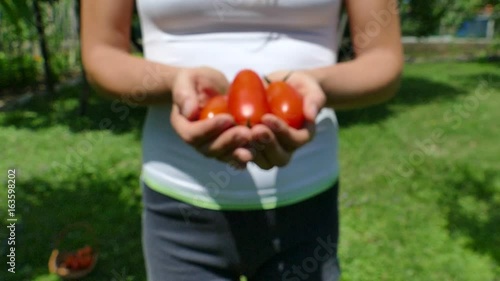 Stretching hands with pelati tomatoes, selective focus, slow motion, FHD photo