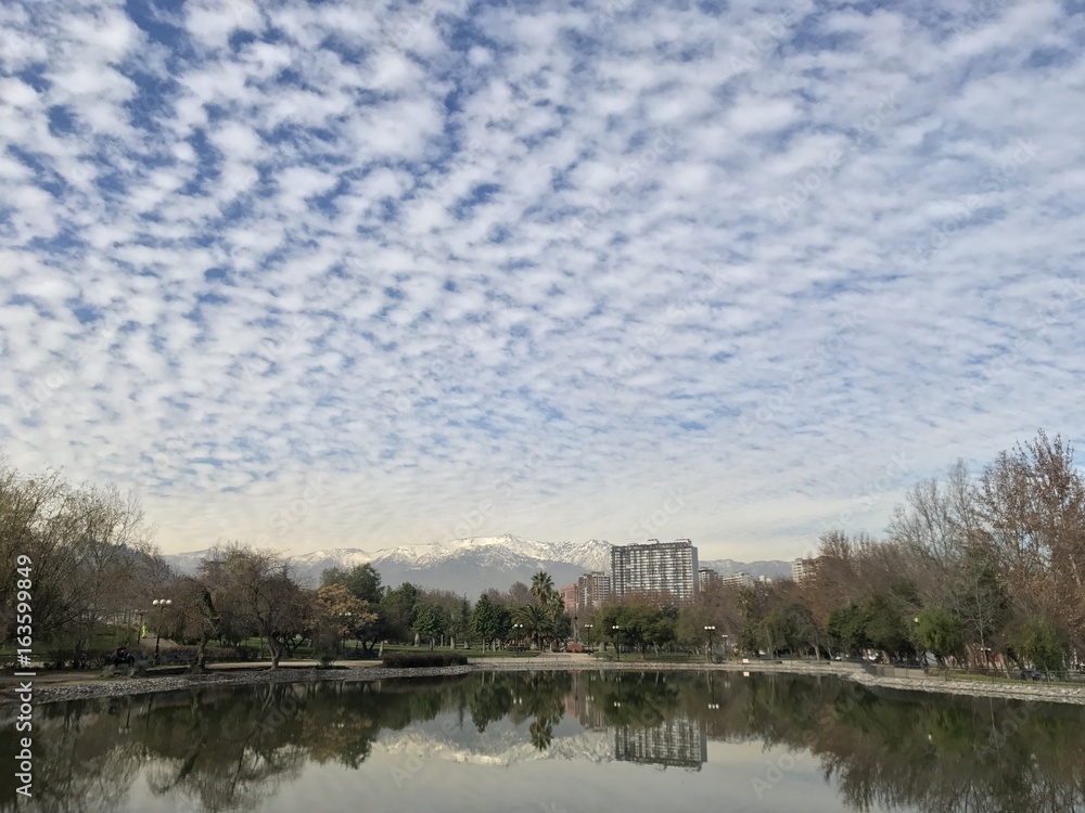 Fototapeta premium Clouds reflex on a pond water at a park in Chile