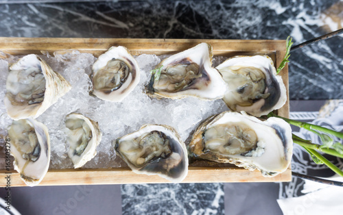 Fototapeta Naklejka Na Ścianę i Meble -  A platter of raw fresh oysters on ice at restaurant.
