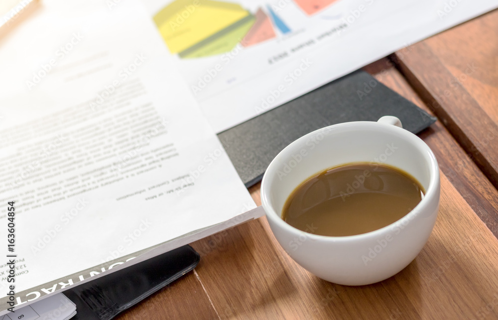 On the desk in office and hot coffee in morning On the desk in office and hot coffee in morning