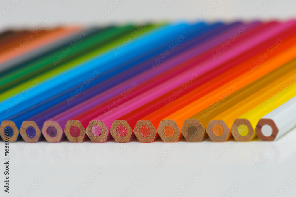 Selective focus of pencil colours on near-white chopping board Selective focus of pencil colours on near-white chopping board
