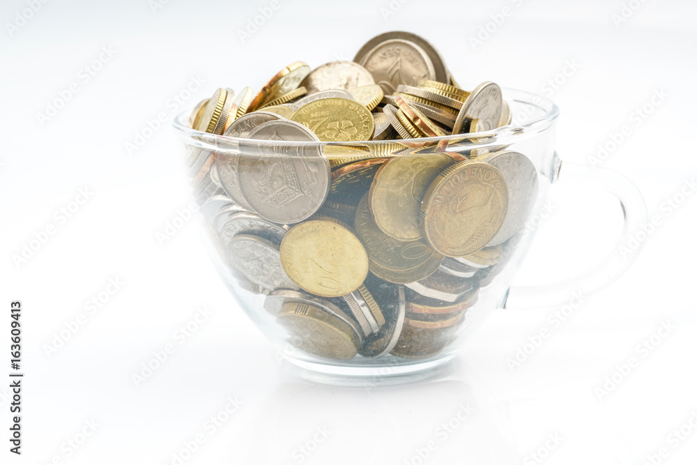 Coins inside cup glass with white background. Coins inside cup glass with white background.