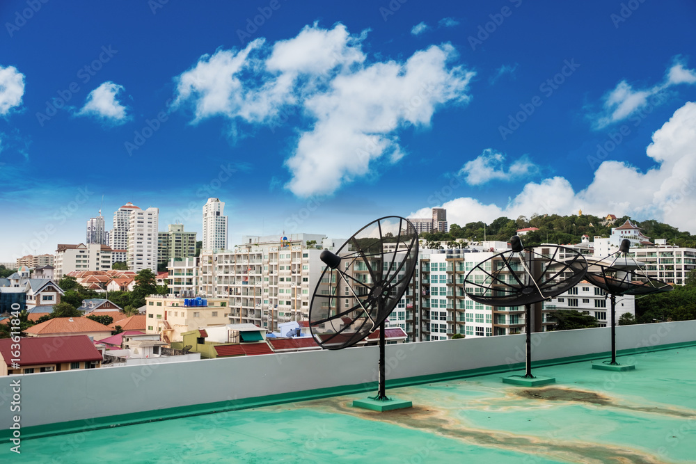 Domestic Satellite Dishes on roof top, with blue sky