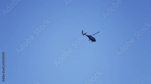 Helicopter flies in the sky. Private helicopter fly on blue sky by day