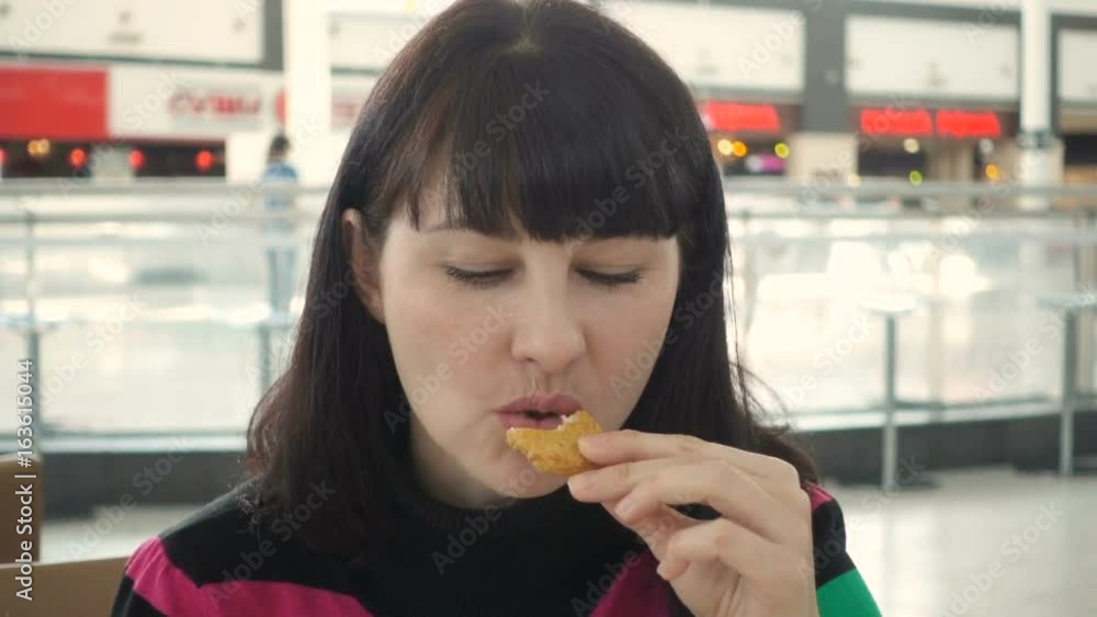 Young woman eating fast food, girl eating , hamburger and Chicken fries in cafe fries in restaurant Young woman eating fast food, girl eating , hamburger and Chicken fries in cafe fries in restaurant
