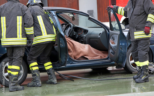 Firefighter team extracts the person from inside the car after a