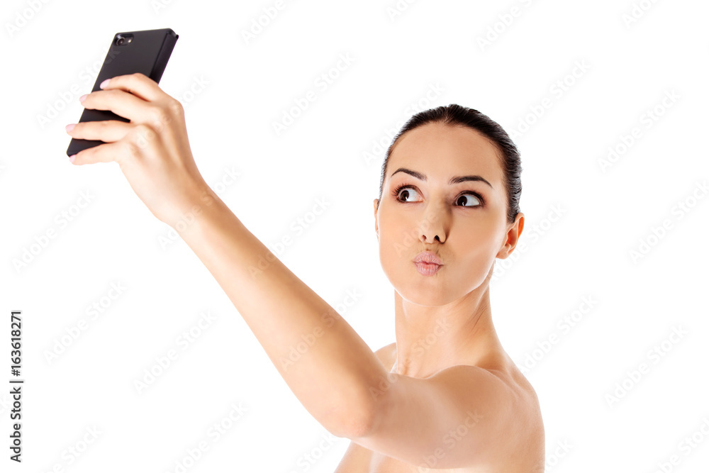 Nude beautiful woman taking selfie on white background. Nude beautiful woman taking selfie on white background.