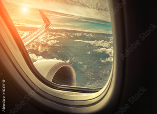 Beautiful view from porthole of airplane on sky with clouds und