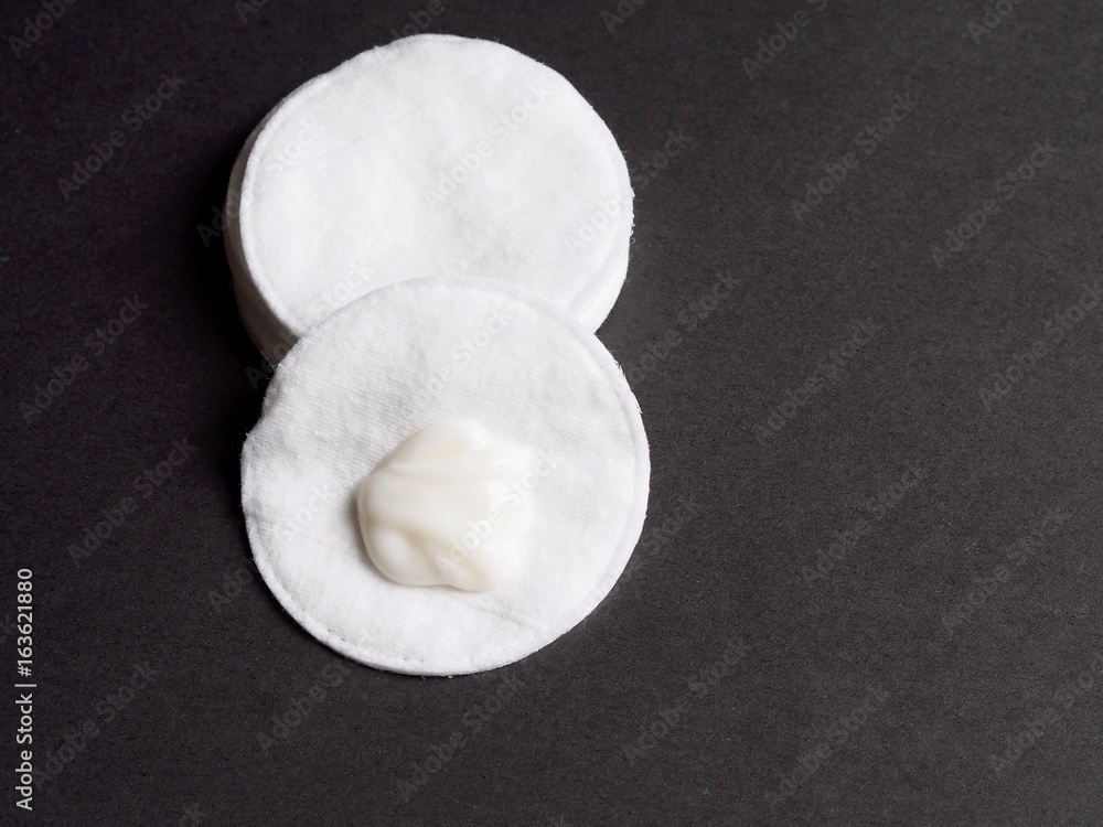 Cotton disc with cream on black background