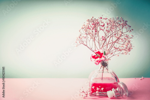 Spa , wellness or natural cosmetic still life with bottle of lotion and flowers on pastel color background, front view, banner, beauty  concept