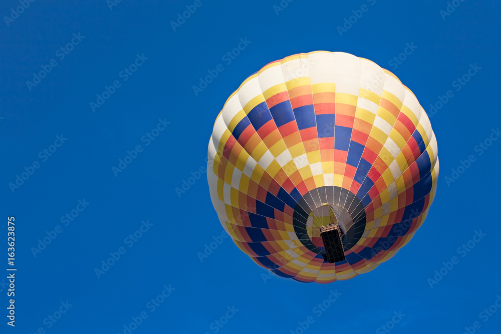 Fototapeta premium Colorful hot-air balloon in flight seen from below