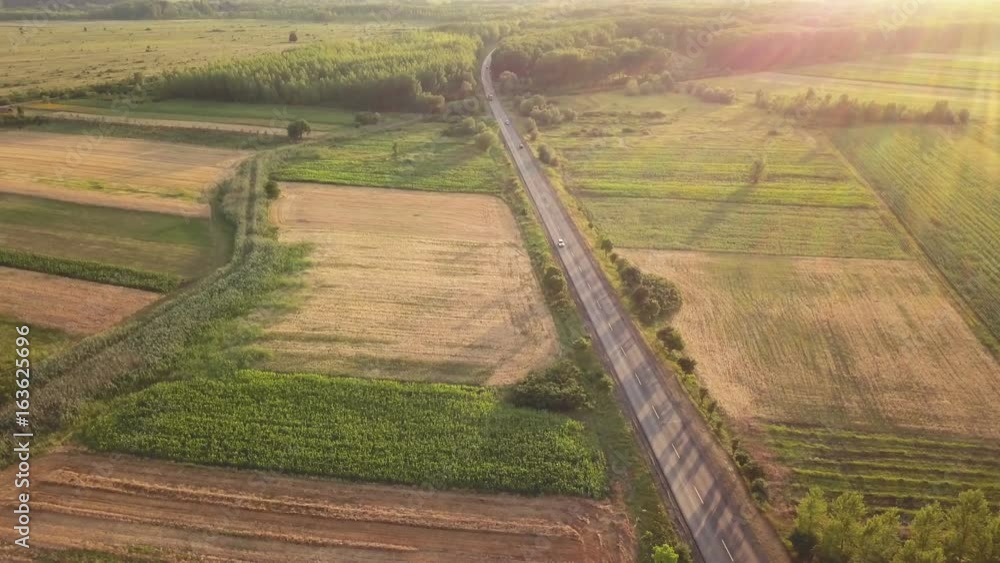 Beautiful aerial view of countryside, road and cultivated fields in sunset, drone point of view Beautiful aerial view of countryside, road and cultivated fields in sunset, drone point of view