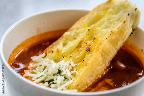 italian minestrone soup with garlic bread and grated cheddar cheese