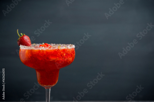 Cocktail strawberry margarita on the wooden background. Selective focus.