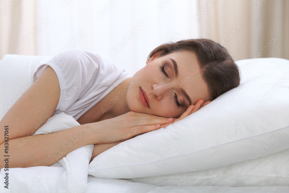 Beautiful young woman sleeping while lying in her bed and relaxing comfortably. It is easy to wake up for work or the day off. Concept of pleasant and rest reinstatement for active life Beautiful young woman sleeping while lying in her bed and relaxing comfortably. It is easy to wake up for work or the day off. Concept of pleasant and rest reinstatement for active life