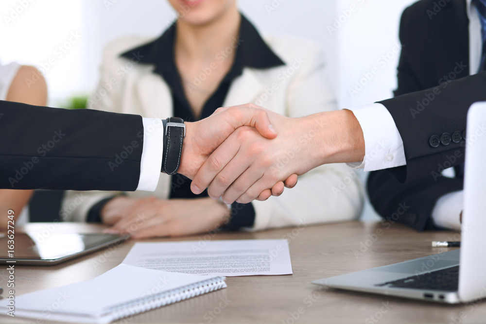 Close up of business people shaking hands at meeting or negotiation in the office. Partners are satisfied because signing contract Close up of business people shaking hands at meeting or negotiation in the office. Partners are satisfied because signing contract