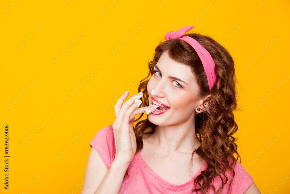 girl in pink dress pinup-style eats cream licks fingers girl in pink dress pinup-style eats cream licks fingers