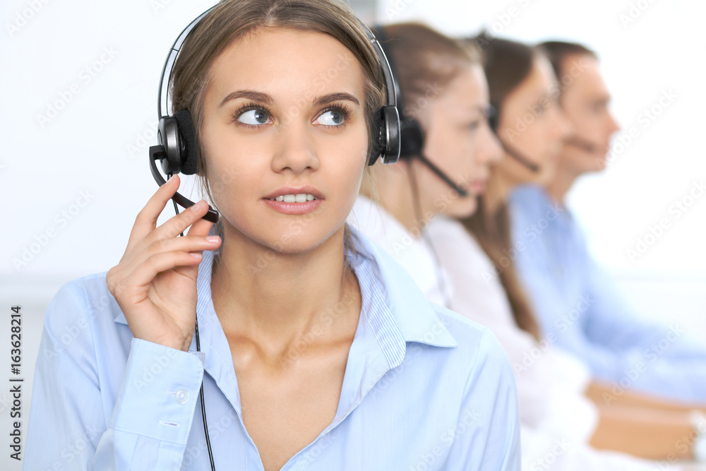 Call center operator in headset while consulting client. Telemarketing or phone sales. Customer service and business concept Call center operator in headset while consulting client. Telemarketing or phone sales. Customer service and business concept