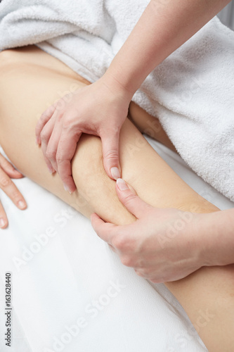 Therapist applying pressure on female leg