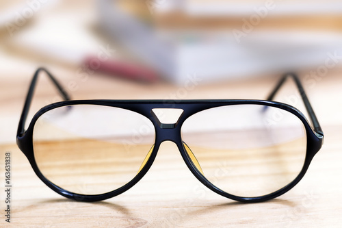 Glasses and book on wooden table.
