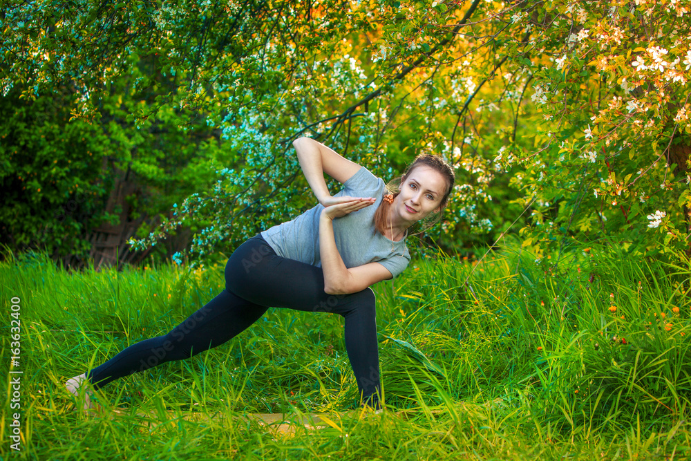 beautiful woman doing yoga outdoors On green grass beautiful woman doing yoga outdoors On green grass