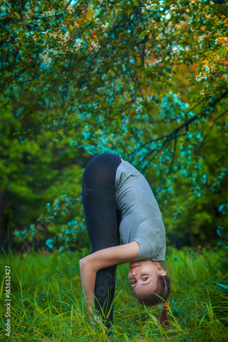 beautiful woman doing yoga outdoors On green grass photo