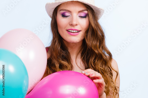 Woman playing with many colorful balloons