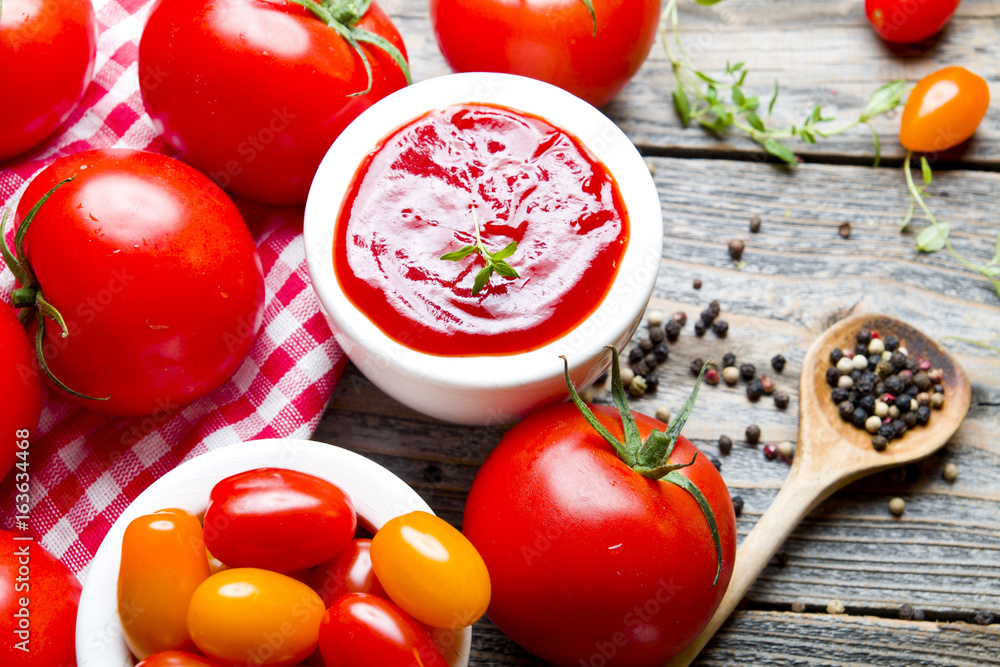 Ketchup with tomatoes on wooden background Ketchup with tomatoes on wooden background