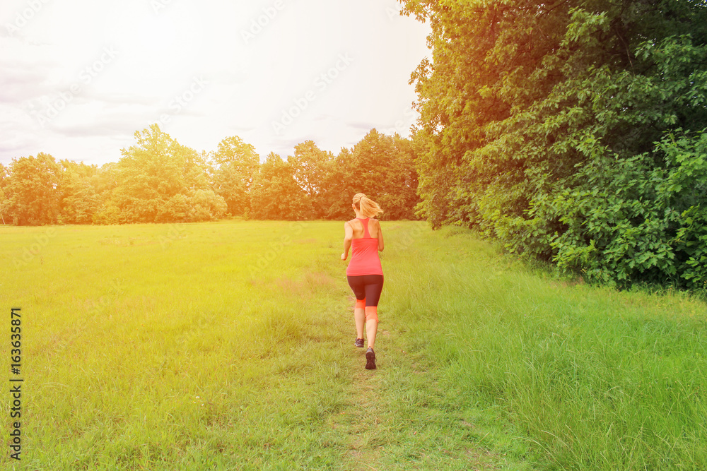 Young woman running from back with strong light. Young woman running from back with strong light.