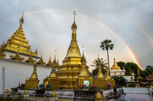 Foto Rainbow over Golden Pagoda Wat Thai Watthanaram in the evening light, Mae Sot, T