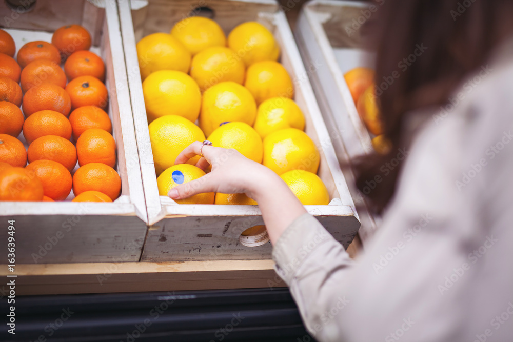 Young woman buying fruit outside the grocery store