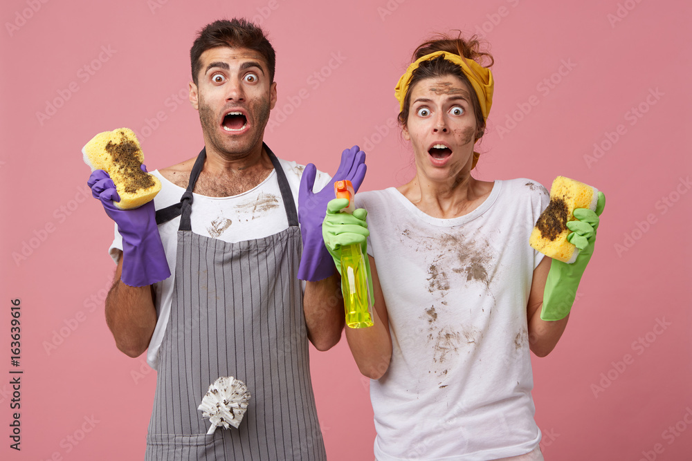 Φωτογραφία Shocked male and female doing chores wearing casual clothes looking with surprisment at very dirty fridge not knowing how to clean it