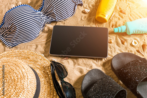 Summer bikini and accessories stylish beach set, Beach bikini summer outfit and sea sand as background, Top View, Concept photo