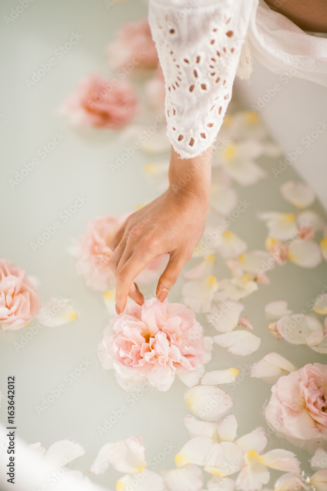 White bath with milk and rose petals. Relaxation and harmony