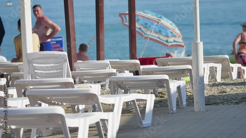 People on the beach by the sea. Sun beds beach on the Black Sea coast in Russia photo