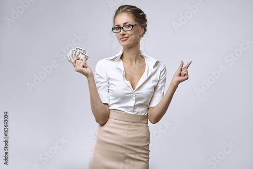 A business lady holds a little money in her right hand and her left hand shows that there is very little money. photo