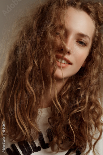 Beautiful girl portrait in studio with curly hair