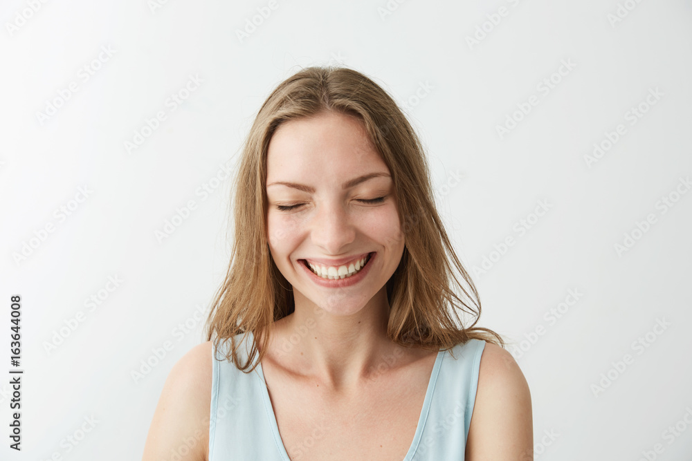 Beautiful sincere happy cheerful girl smiling laughing with closed eyes over white background. Beautiful sincere happy cheerful girl smiling laughing with closed eyes over white background.