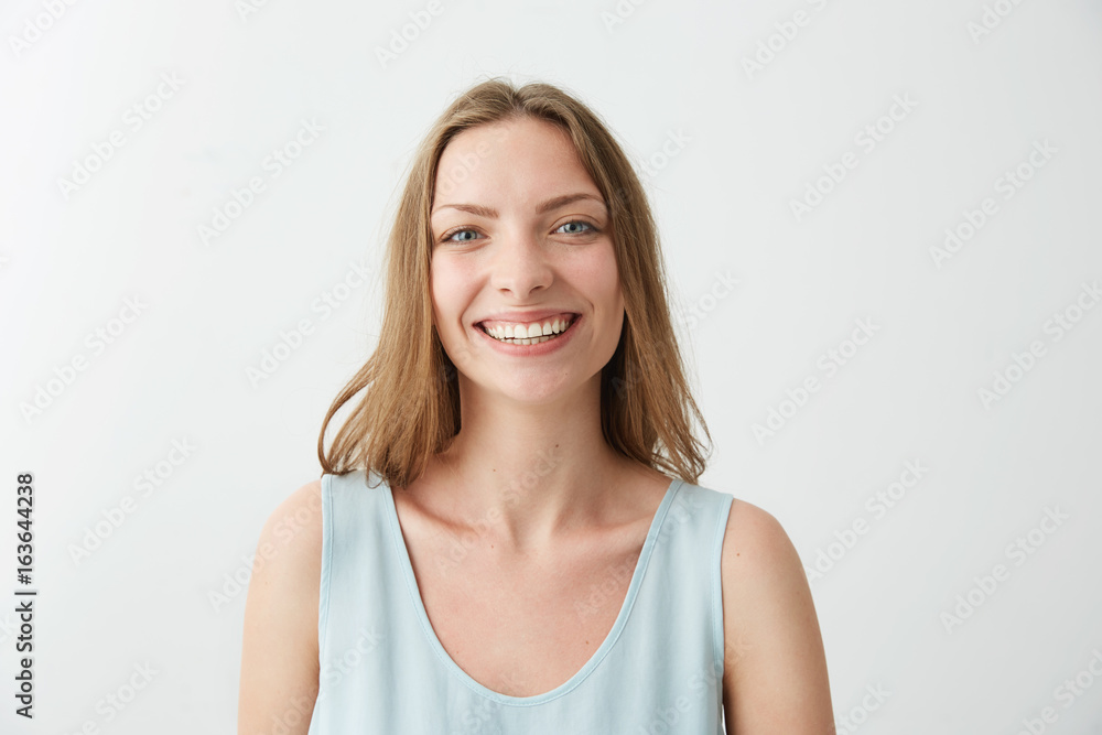 Sincere cheerful happy young girl with blue eyes smiling laughing looking at camera over white background. Sincere cheerful happy young girl with blue eyes smiling laughing looking at camera over white background.