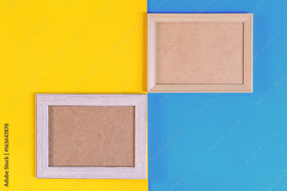 Fototapeta premium Photo wood frame on colorful paper wall background