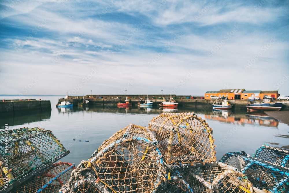 Fototapeta premium Lobster pots stacked onto each other in a small fishing port. Port Seaton, Scotland, UK