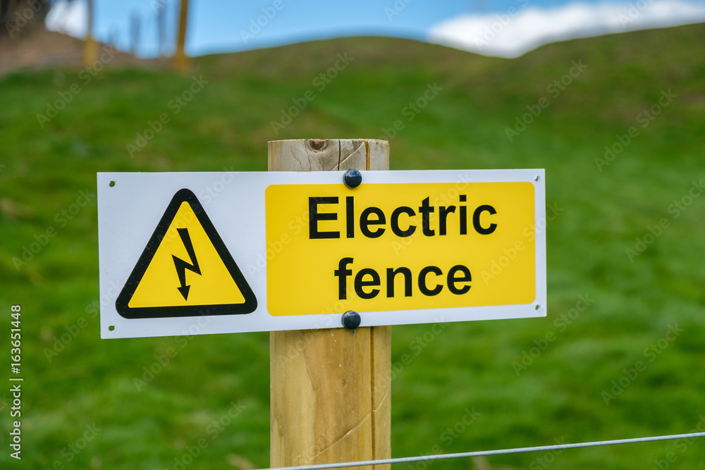 Electric Fence warning sign with rural background. Scotland, UK