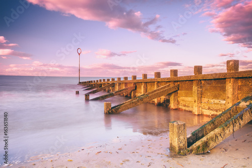Sunset view of Edinburgh's Portobello Beach with wooden groynes. Scotland, United Kingdom