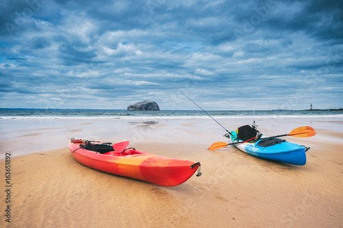 Two kayaks on the beach with the iconic Bass Rock at the background. Near North Berwick, Scotland, UK