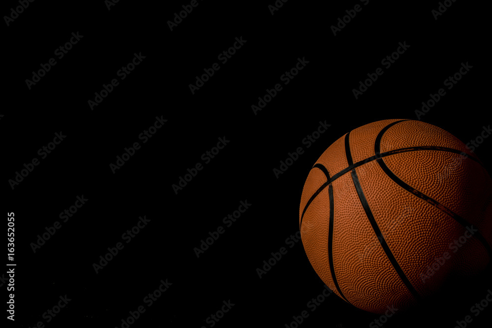 Fototapeta A single basketball isolated on a black background