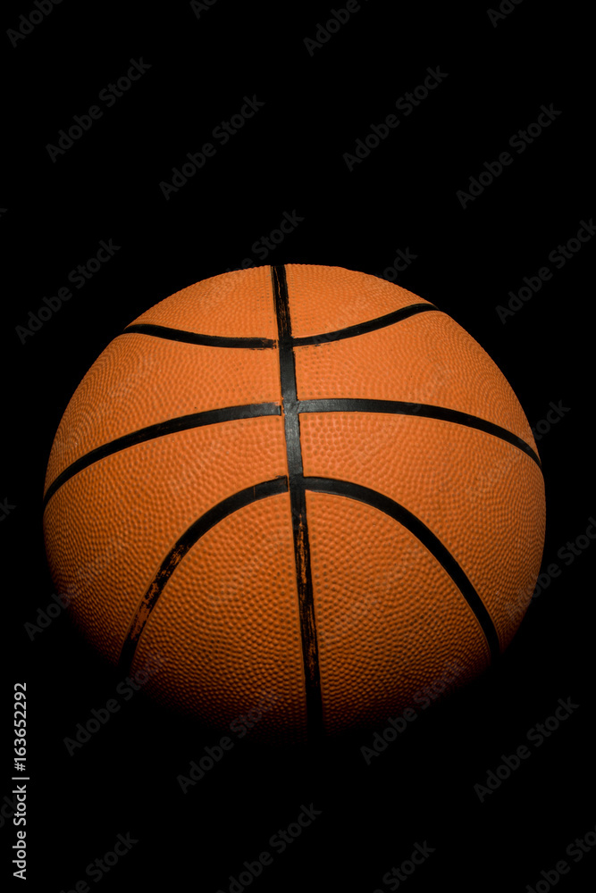 A single basketball isolated on a black background A single basketball isolated on a black background